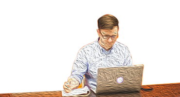Mann mit Laptop am Schreibtisch